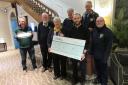 A photo showing charity members with the cheque