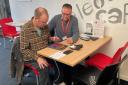 Spark iT Digital Champion Carl Butler works with Chard resident, Jonathan at the Eleos Café on Fore Street