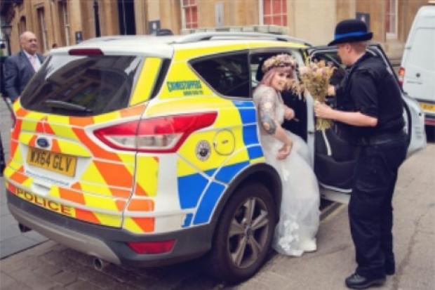 PC Bridget Griffiths helping the bride, Yasmin, out of the police car