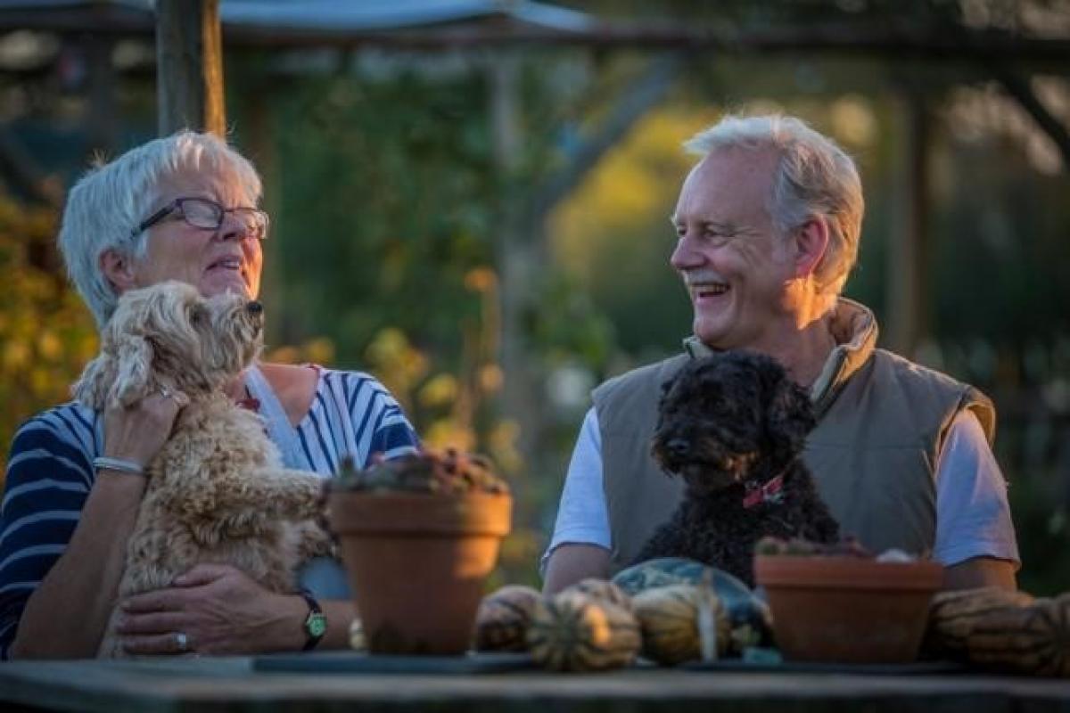 Kath and Trevor in the garden with their dogs Chip and Hazel