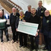 A photo showing charity members with the cheque